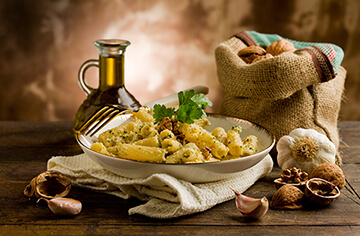 A bowl of pasta with garlic and parsley.